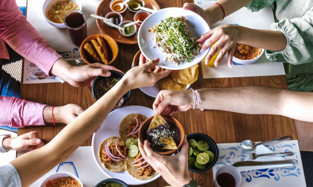 Friends toasting over a table of traditional Mexican dishes at a post-tour dinner