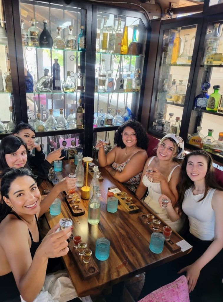 A group of smiling women enjoying a tequila tasting.